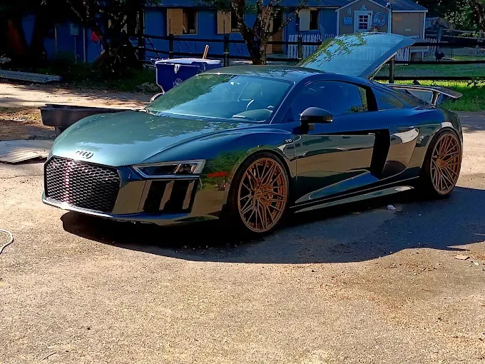 Green Audi R8 with bronze wheels on a gravel driveway after a full detail